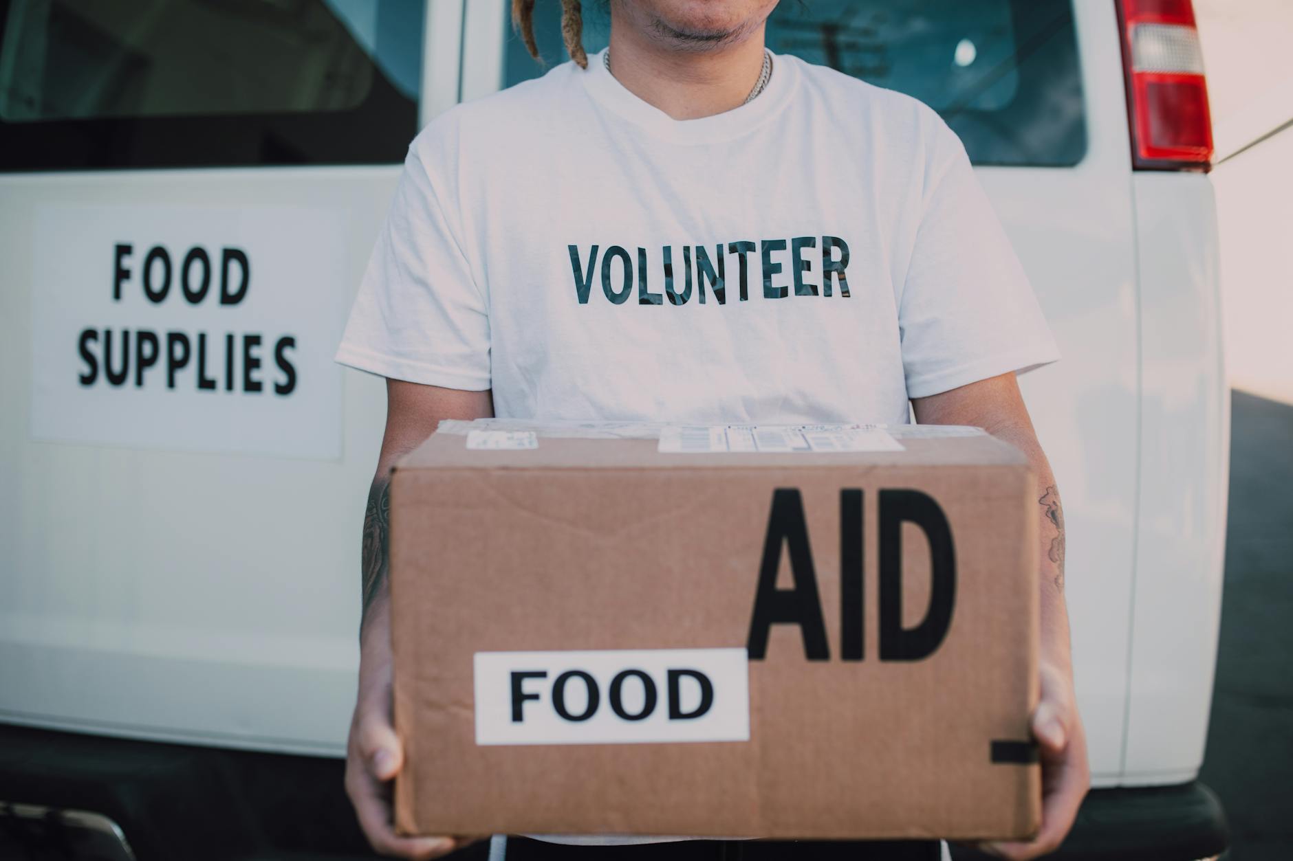 volunteer holding box of food aid